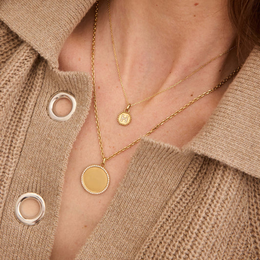 2 chaines autour du cou d'une femme et médailles avec diamants